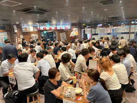 新宿三丁目の新時代 新宿靖国通り店の店内で、多くのお客様がテーブルを囲んでにぎわう様子の写真