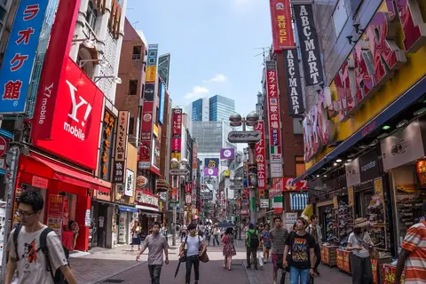 渋谷のセンター街と見られる、看板が立ち並ぶ賑やかな商店街の通りの写真