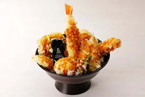 天丼専門店 ゑるびすの、大きなエビ天が3本盛られた黒い丼の天丼メニューをアップで撮影した写真