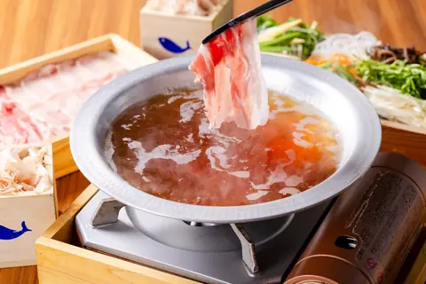 出汁しゃぶ おばんざい おかかの出汁鍋に豚肉を箸でくぐらせている写真