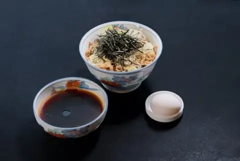 恵比寿 港屋の天かすと刻み海苔をのせた冷たい肉そばに、つけ汁と温泉卵が添えられた写真