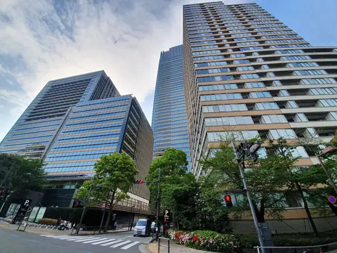東京ミッドタウンの高層タワーを交差点側から見上げた外観の写真