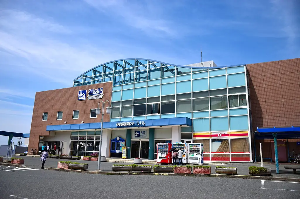道の駅伊良湖クリスタルポルト（田原市）の、レンガとガラスの外壁の建物と入口の自販機と人の写真