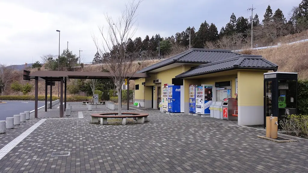 内子パーキングエリアの、瓦屋根の建物と自販機、前の石だたみの広場と木の屋根の休憩所の写真