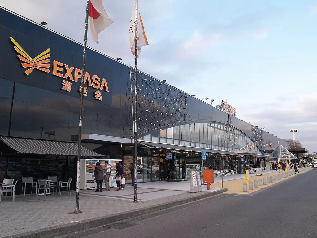 海老名サービスエリア（上り）の、「EXPASA海老名」の看板が付いた黒い大きな建物と、前を歩く人たちの写真