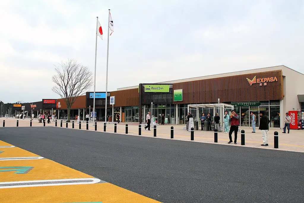 足柄サービスエリア（東京方面）の、「EXPASA」の看板が付いた横に長い建物と旗ざお、前の広い歩道の写真