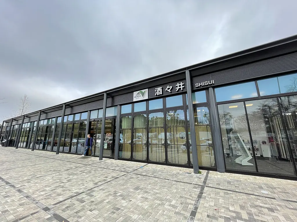 酒々井パーキングエリア（下り）の、「酒々井」の看板が付いたガラス張りの横に長い建物の写真
