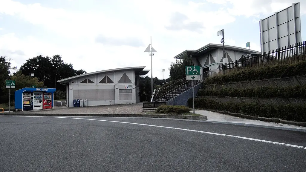 由良川パーキングエリアの、丸い屋根の小さな建物と自販機、坂の上へ続く階段と手前の道路の写真