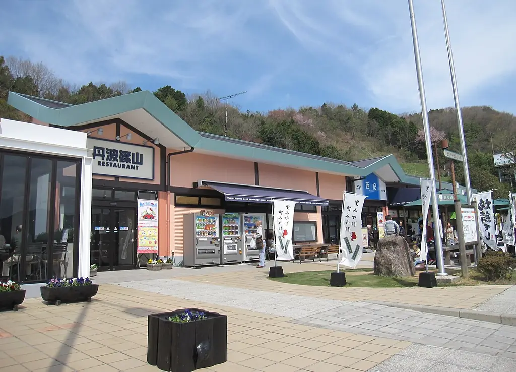 西紀サービスエリア（下り）の、「丹波篠山」の看板が付いたレストランの建物と、自販機とのぼりが並ぶ前の広場の写真