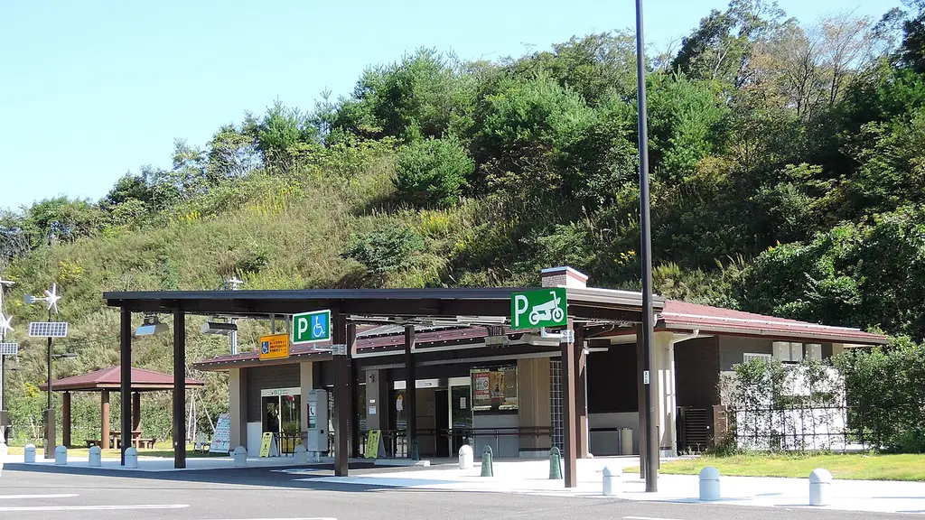 加茂岩倉パーキングエリアの、P看板の付いた屋根の通路と建物、うしろの木の茂った斜面の写真