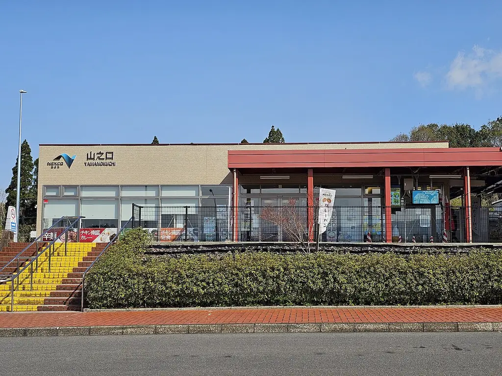 山之口サービスエリア（北側）の、「山之口」の看板が付いた建物と赤い柱のテラス、手前の植え込みと階段の写真