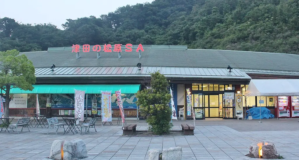 津田の松原サービスエリアの、「津田の松原SA」の文字が屋根に付いた建物と、前のテラス席の写真