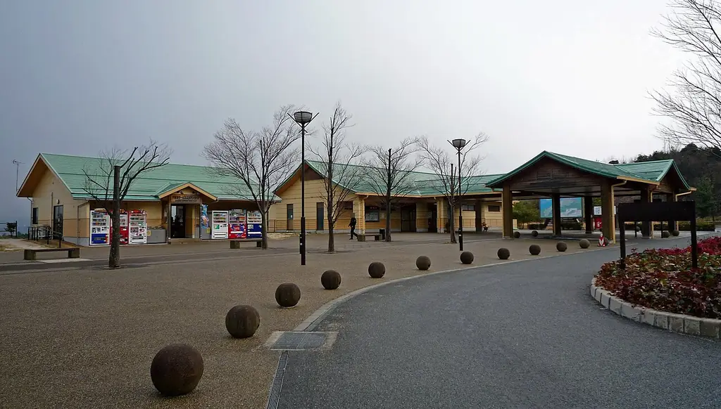 宍道湖サービスエリア（下り）の、緑の屋根の建物が並ぶ広場と、カーブする歩道と丸い車止めの写真