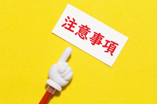 注意事項と書いた紙を指し示す指のイラスト