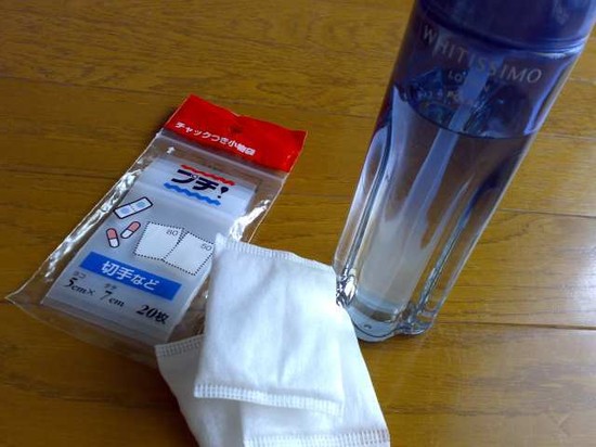 チャック付きの小袋と化粧水のボトルとタオルを机に並べた写真