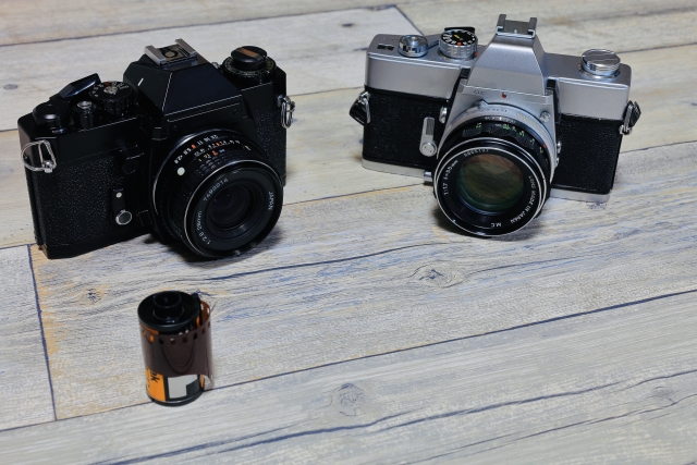 黒と銀のフィルム一眼レフ2台とフィルムケース