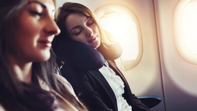 機内で肩を寄せて眠る女性2人