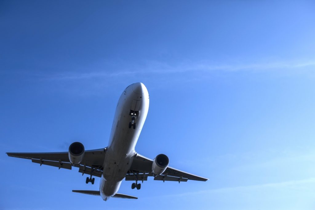 青空へ向かって上昇する旅客機