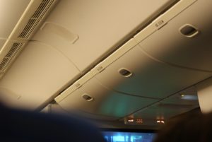 機内の天井にある収納棚と非常灯