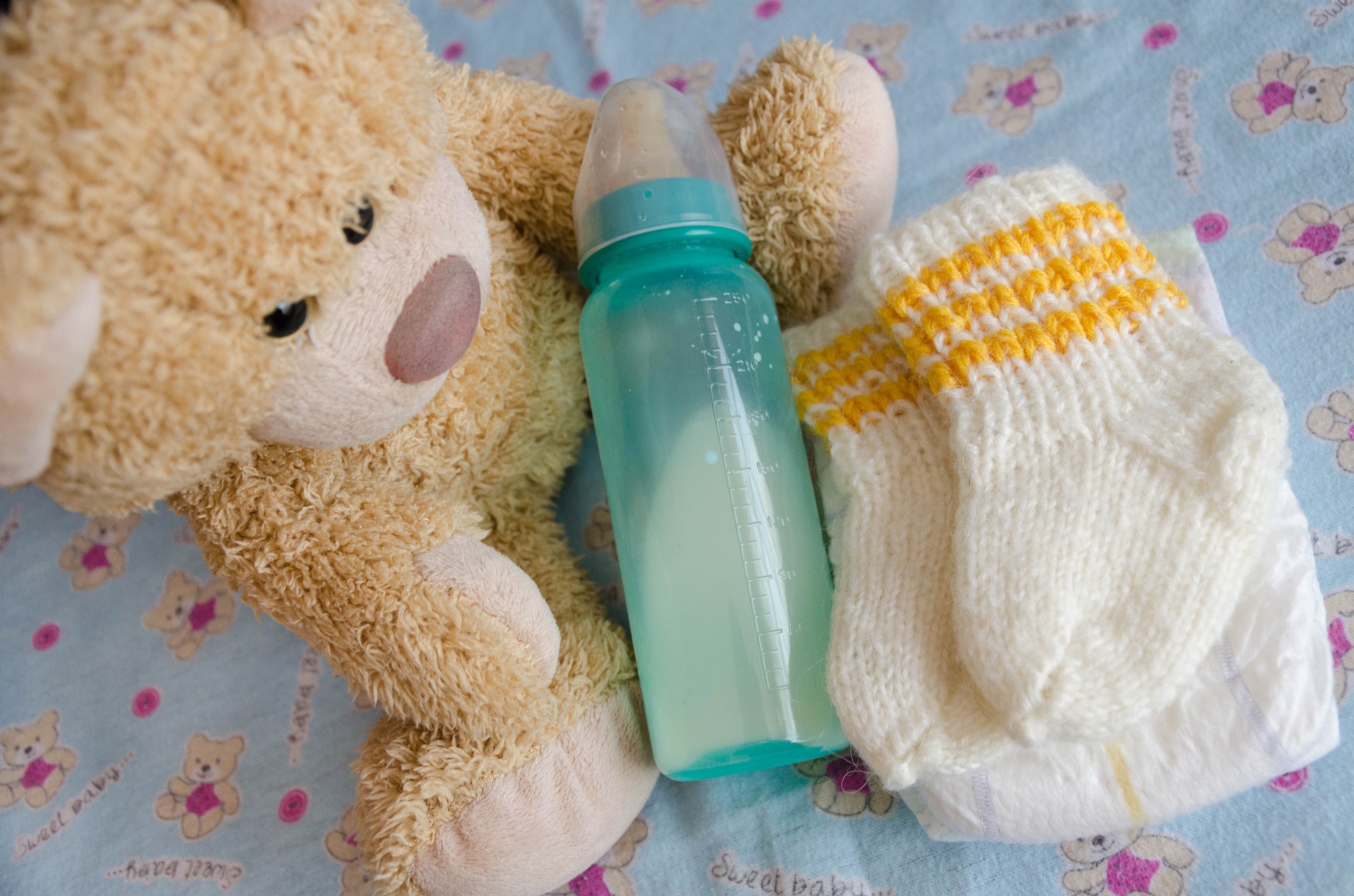 ぬいぐるみと哺乳瓶と紙おむつを並べた写真