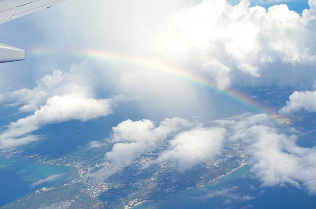雲海の上にかかる虹と、下に見える海岸線