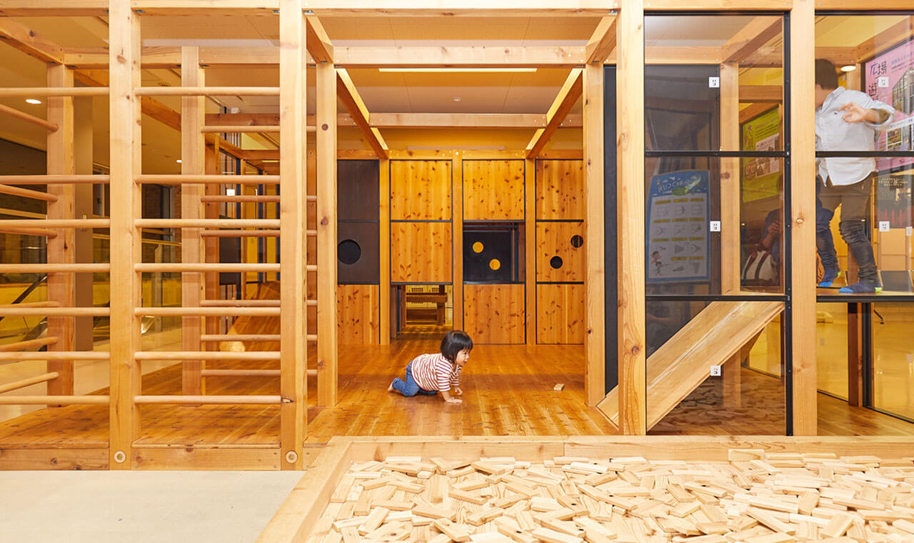 木のジャングルジムがある屋内の遊び場