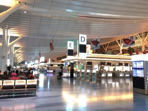 空港のチェックインカウンターが並ぶ広いフロア