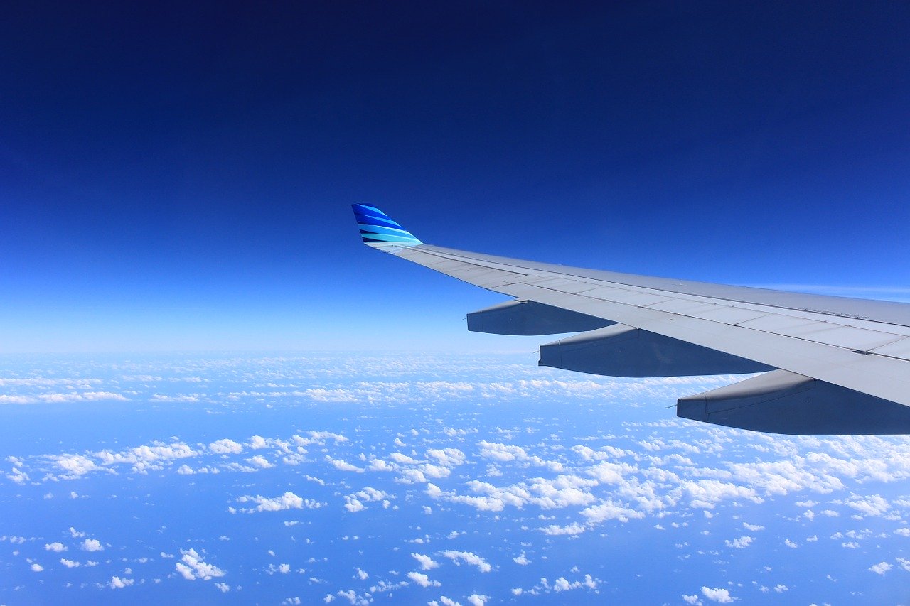 高高度から見た青い空と雲海と主翼