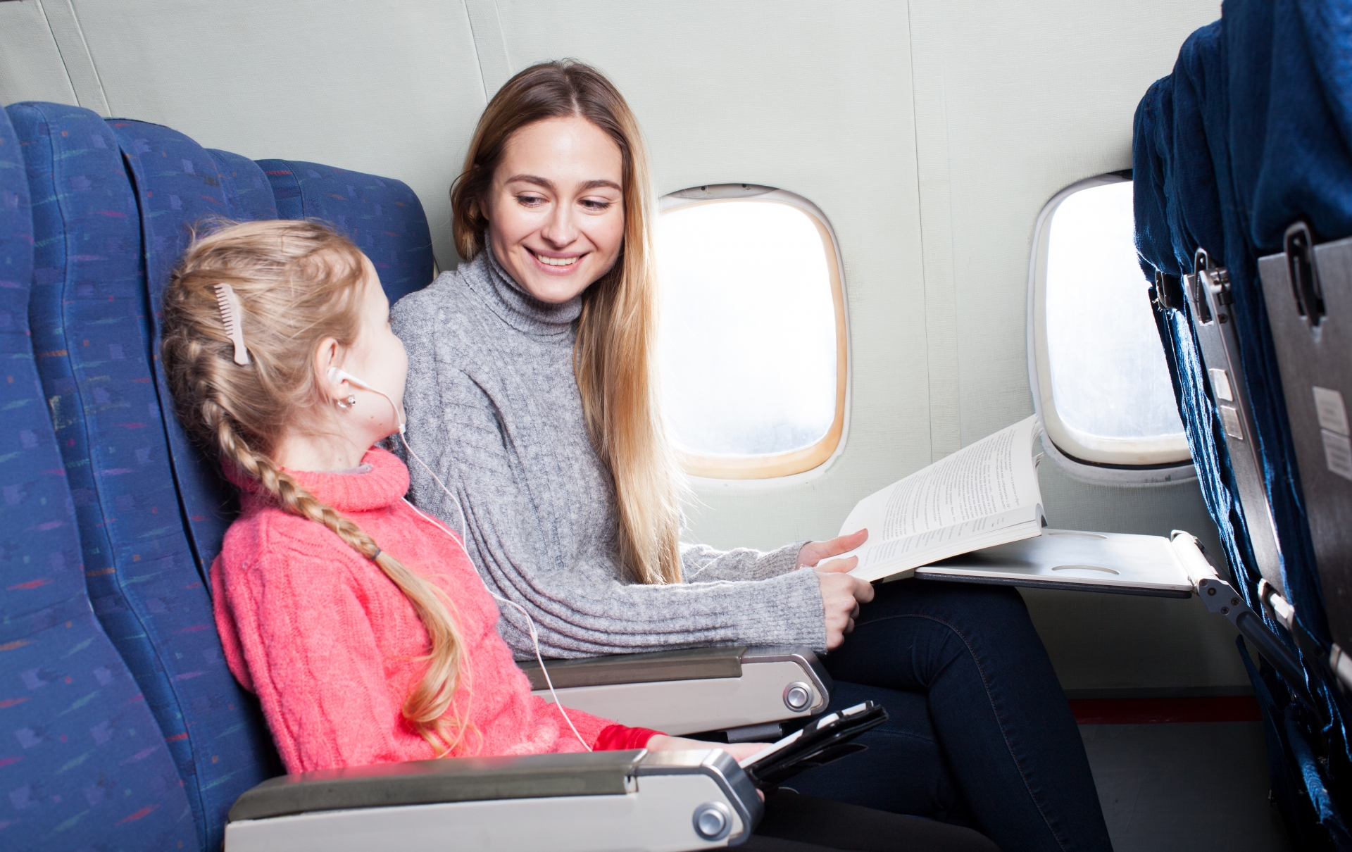 機内で女の子と本を読む女性