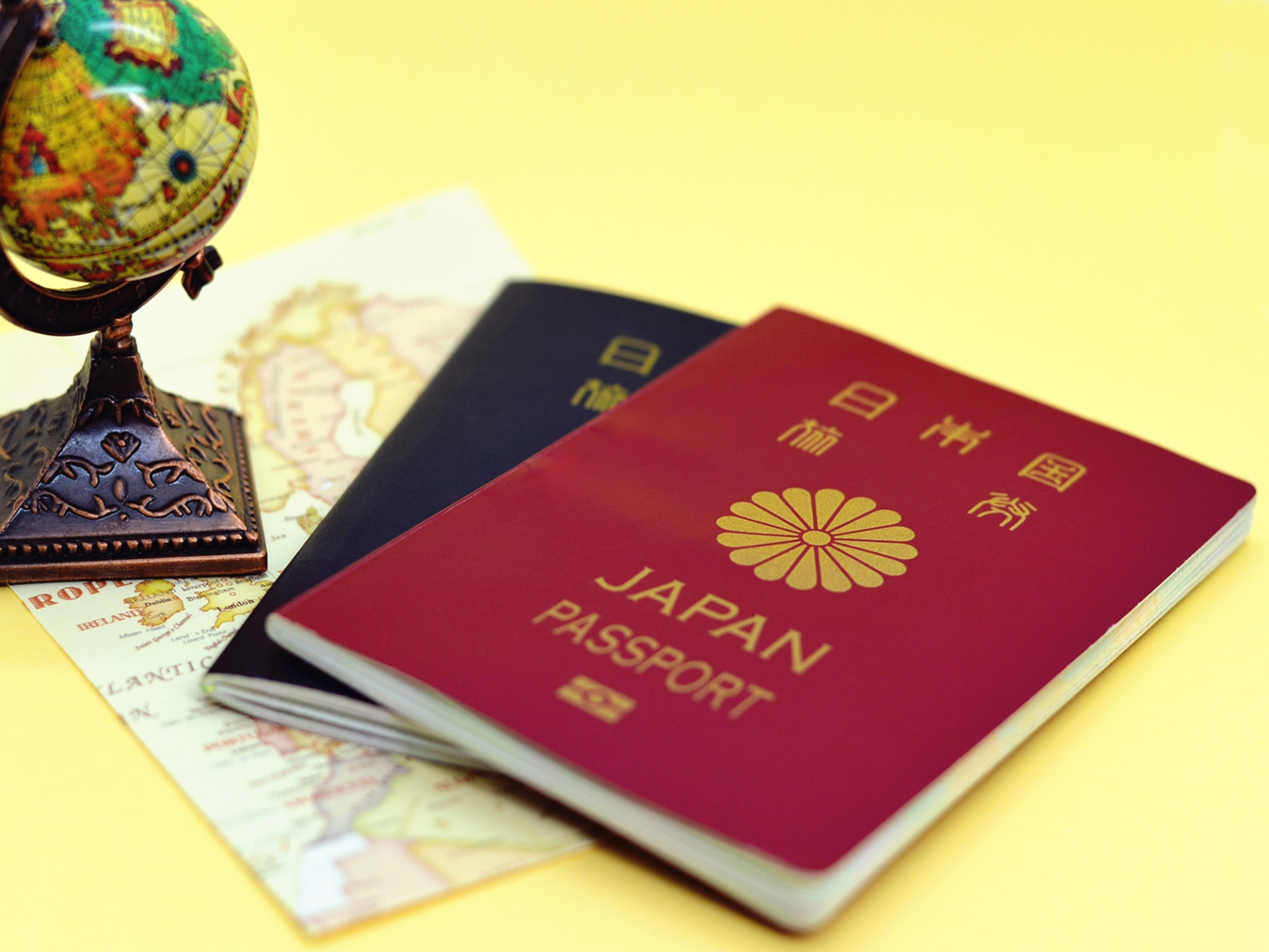 地球儀と日本のパスポートと世界地図