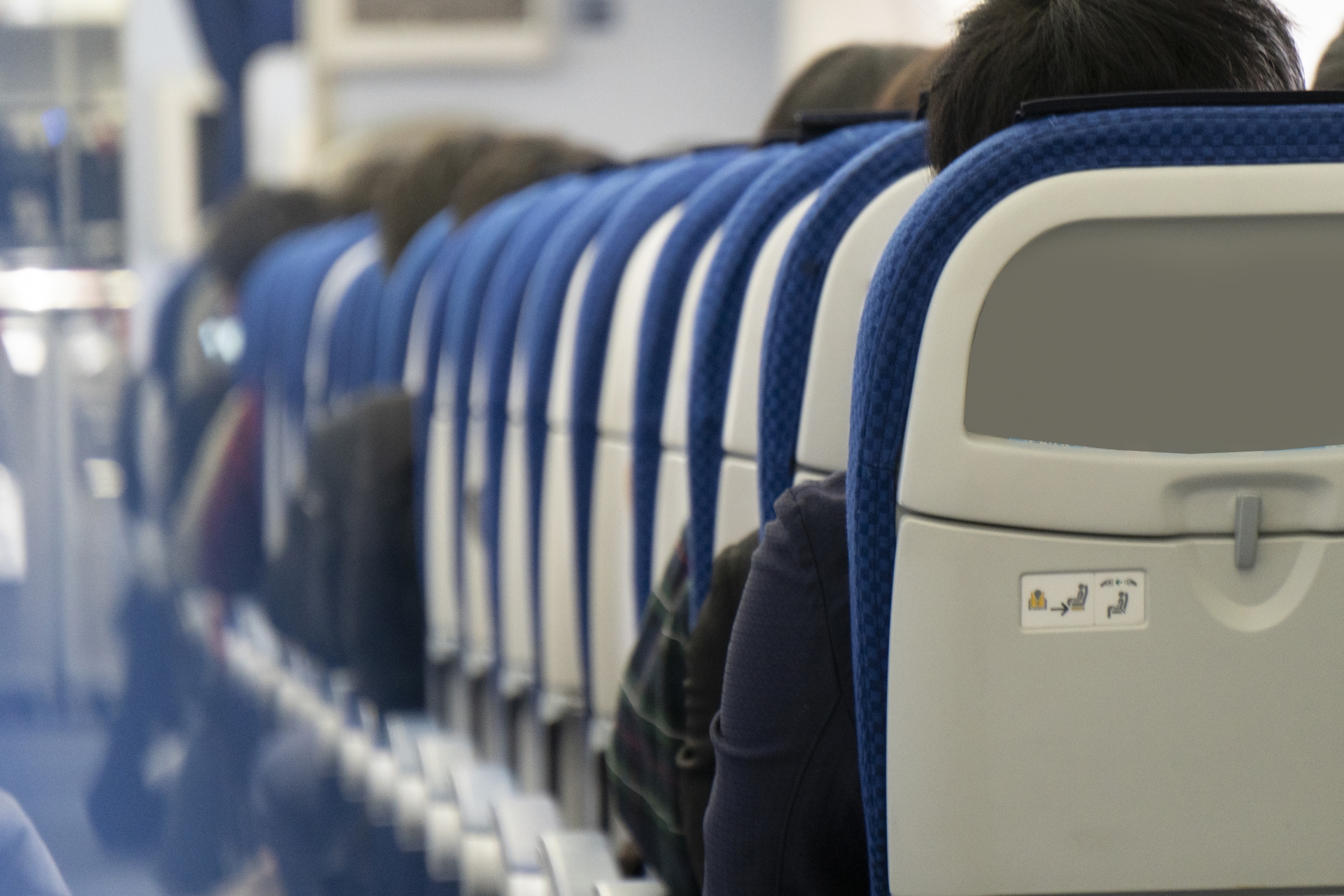 紺色の座席が並んだ機内を斜め後ろから見たところ