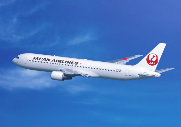 青空を飛ぶ日本航空の旅客機
