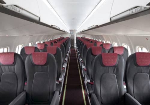 赤いヘッドレストが並んだ小型機の機内
