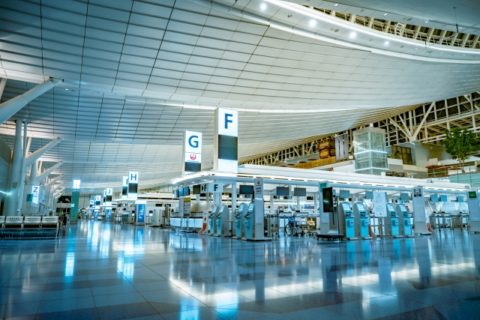 青い照明の空港の出発フロアと搭乗口の案内標識
