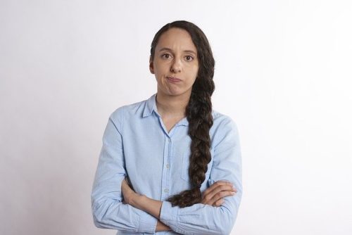 腕を組んで困った顔をしている女性