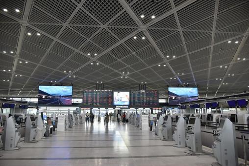 天井の高い空港の出発フロアと自動チェックイン機