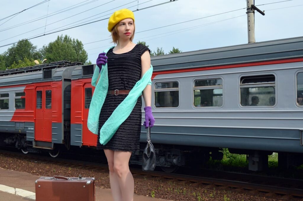 駅のホームでストールを掛けて立つ女性