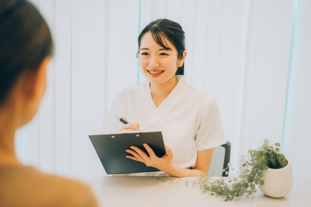 問診票に記入する女性の医療スタッフ
