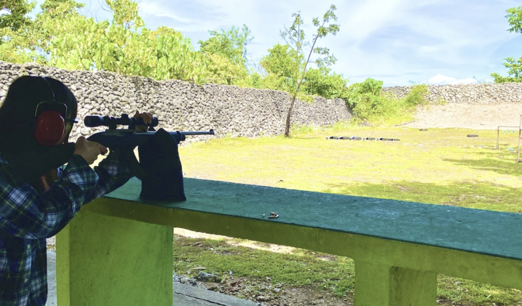 屋外の射撃場でライフルを構える人