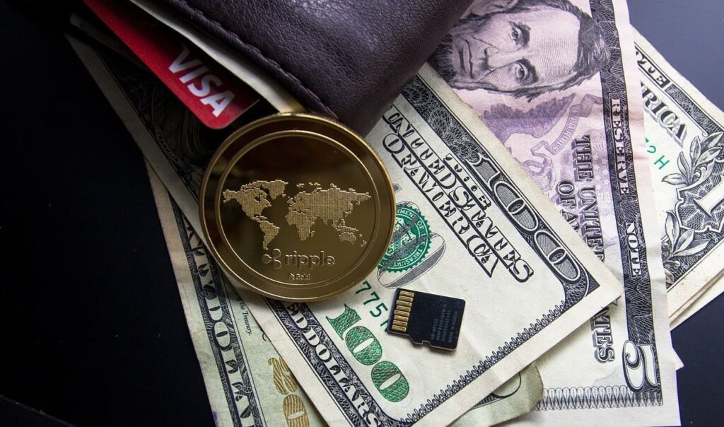 革の財布とクレジットカードとドル紙幣と金色のコイン