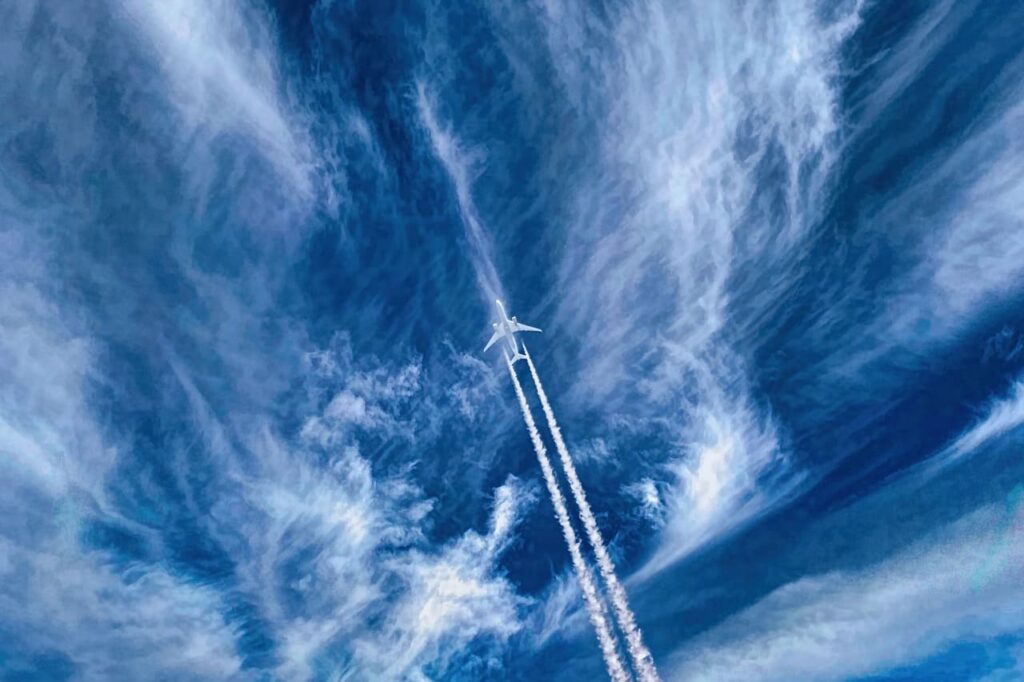 すじ雲の空に伸びる飛行機雲