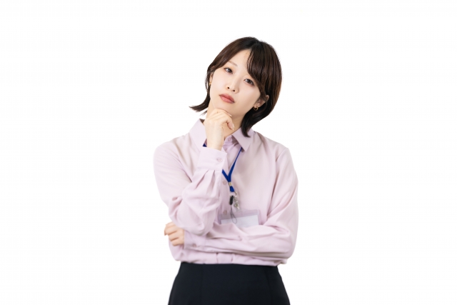 あごに手を当てて考えるスーツ姿の女性