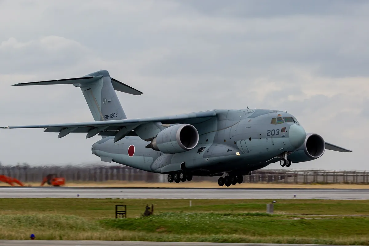 航空自衛隊のC-2輸送機が滑走路で着陸する様子を側面から写した写真