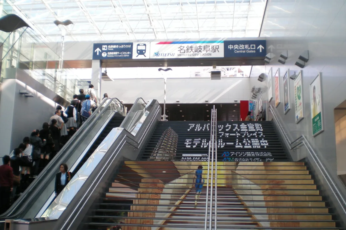 「名鉄岐阜駅」の案内板が掲げられた改札前のエスカレーターと階段の様子を写した写真