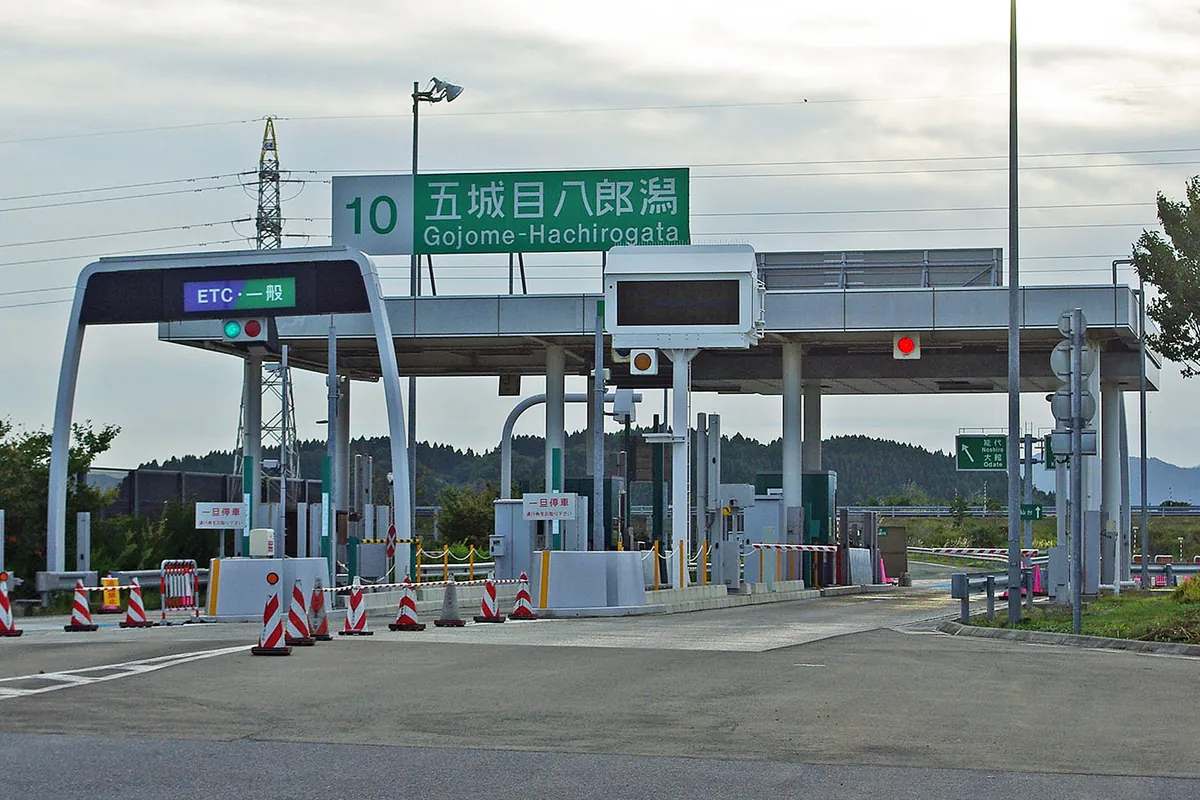 秋田自動車道の五城目八郎潟IC料金所で、ETC・一般レーンのゲートと案内標識が設置されている様子の写真