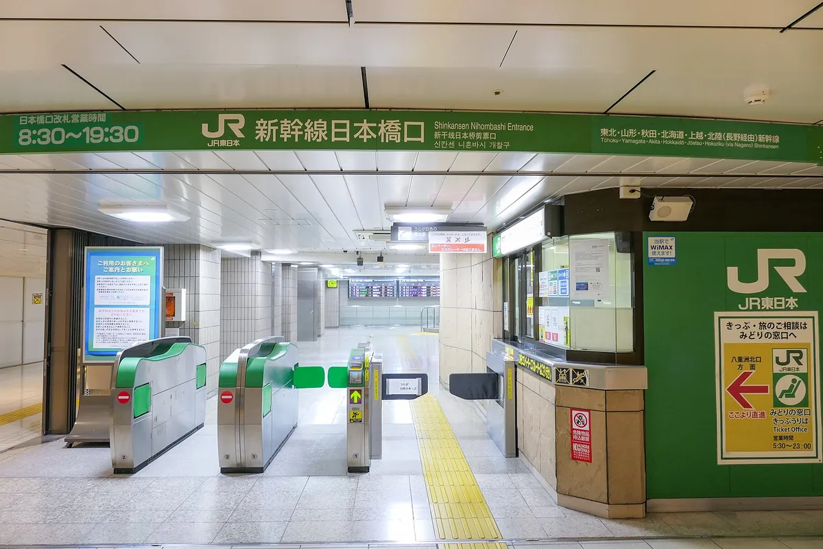 JR東日本の東京駅新幹線日本橋口で、緑色の自動改札機と案内表示が並ぶ様子の写真