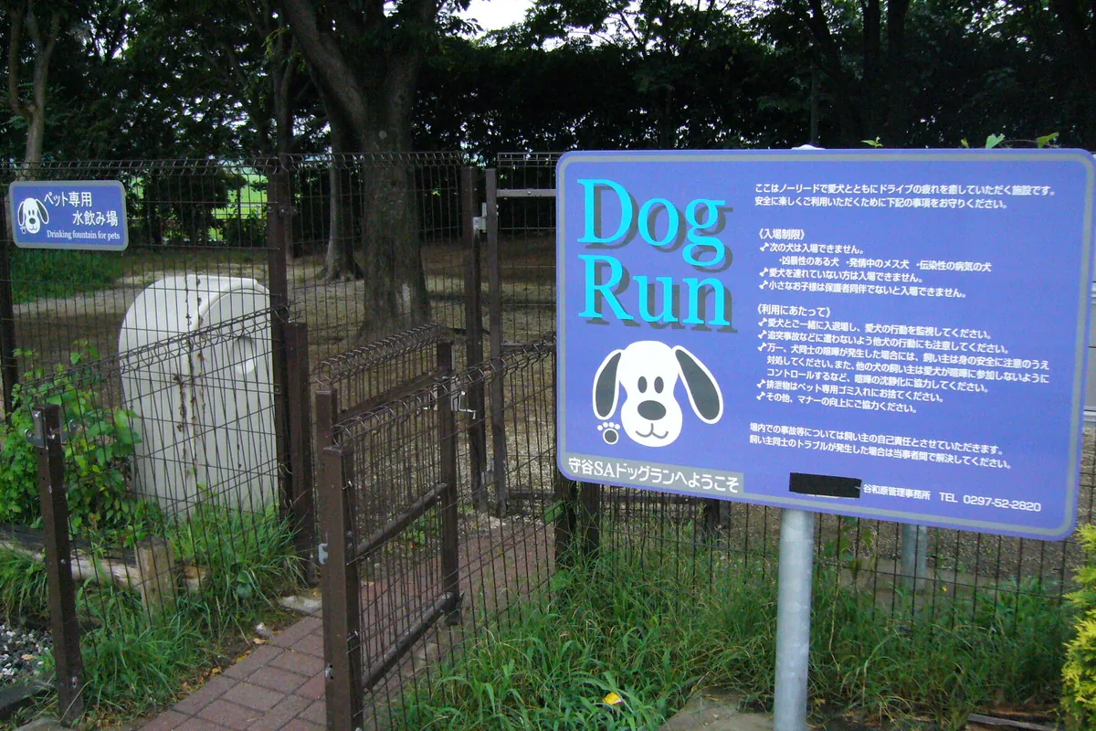 サービスエリアのドッグランの入口に「Dog Run」と書かれた案内看板とフェンスが設置されている様子の写真