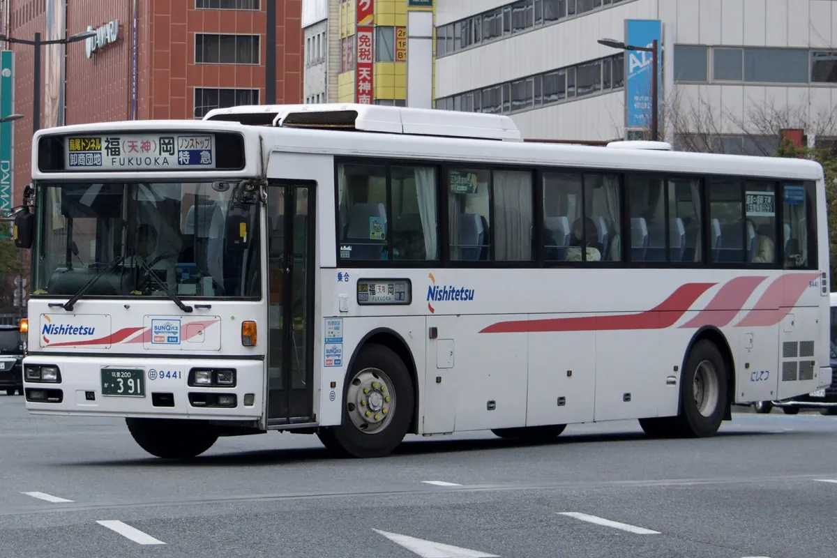 「Nishitetsu」の文字と「福岡 FUKUOKA 特急」の行先表示がある白い高速バスが道路を走る写真