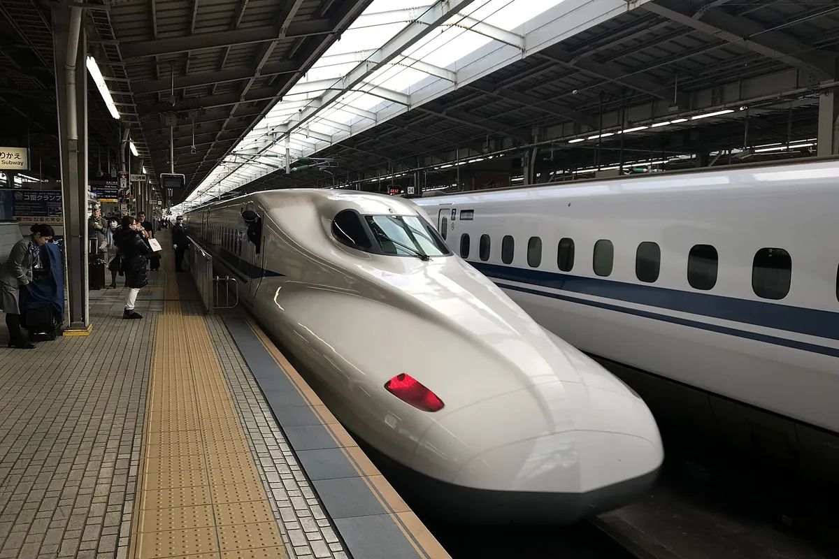 新幹線の駅ホームに停車するN700系のぞみの先頭車両と、隣のホームに停まる別の新幹線車両の写真