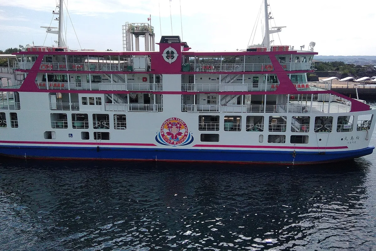 「SAKURAJIMA FERRY LINE」と書かれた桜島フェリーの船体が港に停泊している写真